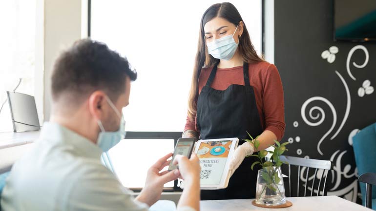 A customer being served by server and both are wearing masks