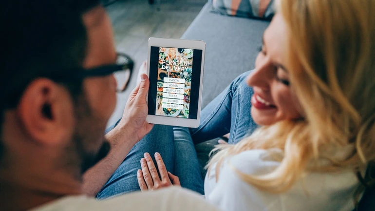 A couple looking at an online menu together