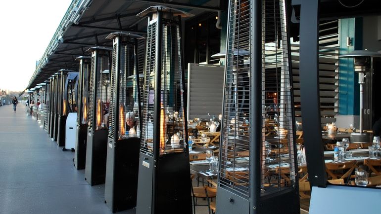 An outdoor patio with standing heaters