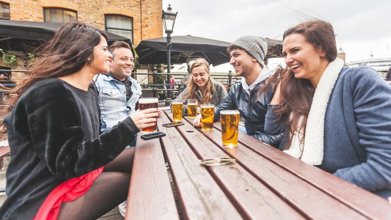 Group of friends enjoying a beer on a pub patio
