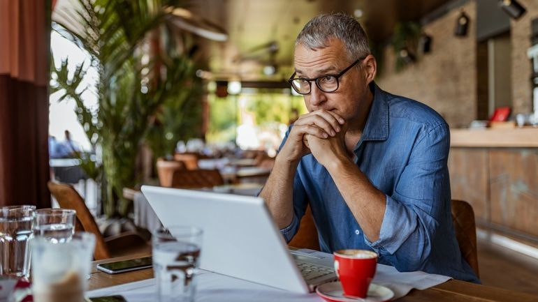 Worried business owner sitting in front of a laptop