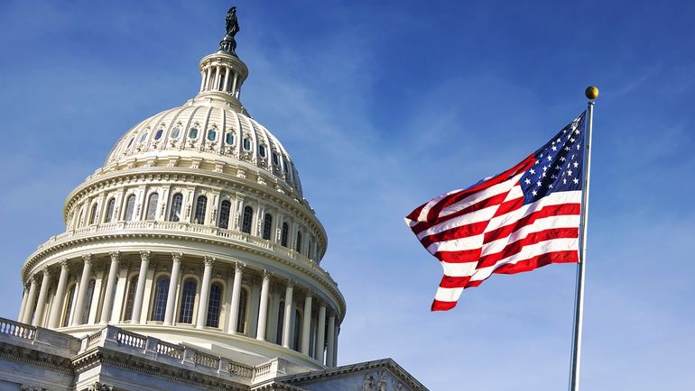 American flag waving in front of Capitol Hill