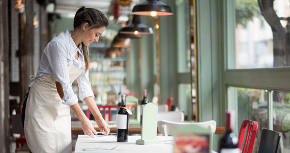 Waitress setting up a table in a restaurant