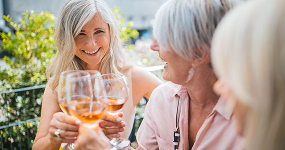 3 customers cheersing outside in the summer