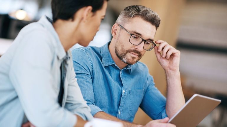 Two restaurant owners sitting at an iPad working on a communication plan