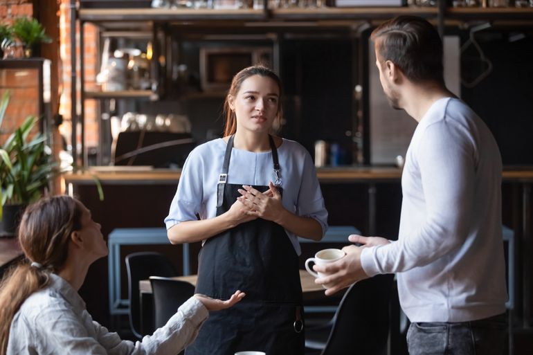 Server looks uncomfortable between two angry customers, might have to comp a meal