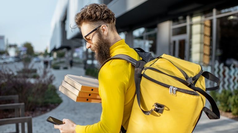 food delivery worker checking his phone to see where his next delivery is