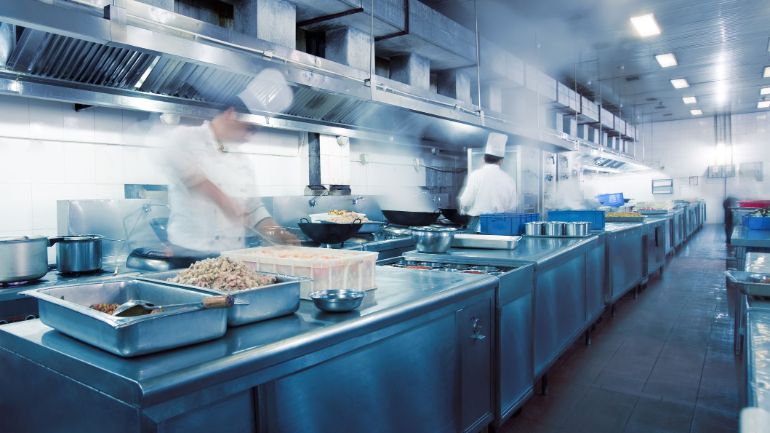 Chefs moving rapidly in a restaurant kitchen