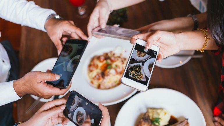 People photographing dishes with their smartphones