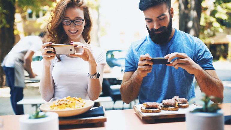 Couple taking pictures of the dishes they have been served