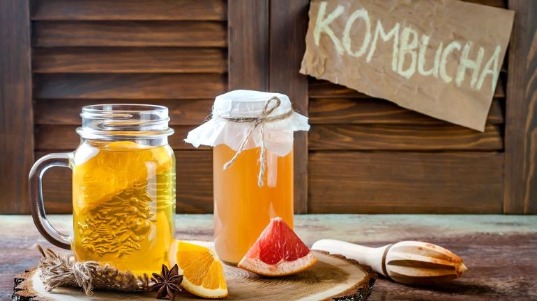 Kombucha in a mason jar style mug with slices of citrus