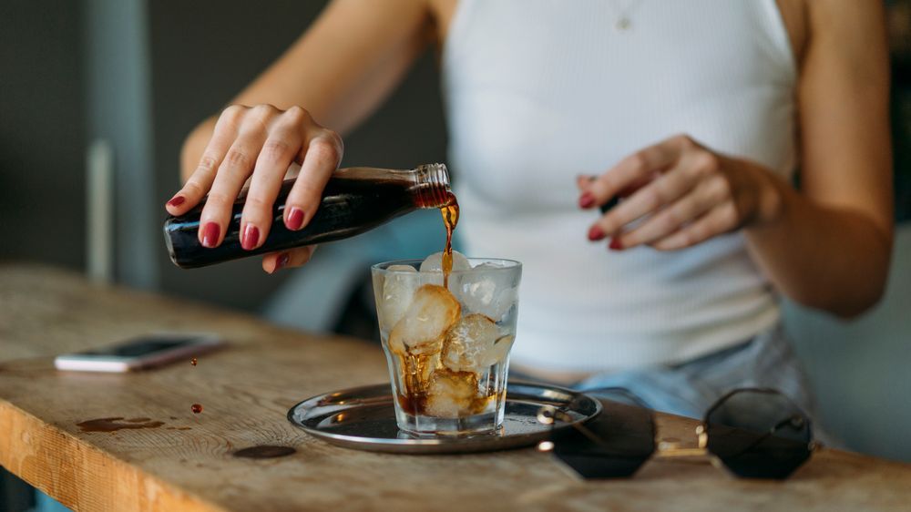 Server pouring a drink over ice