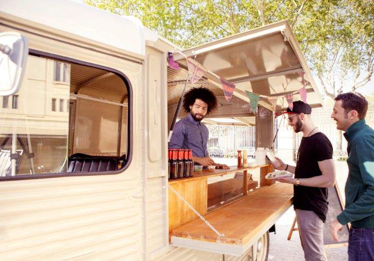 Food truck worker serving customers through service window