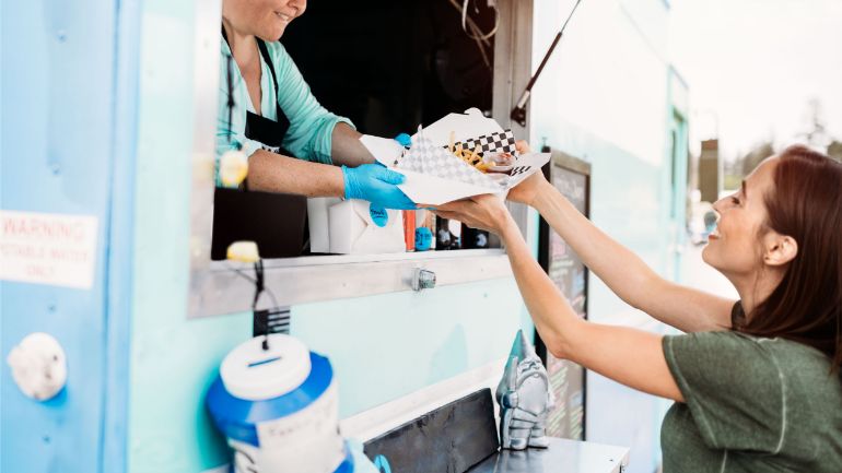 Customer receiving her order through a food truck window