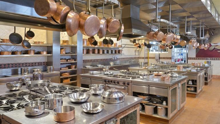 Commercial kitchen with lots of hanging copper pots and pans