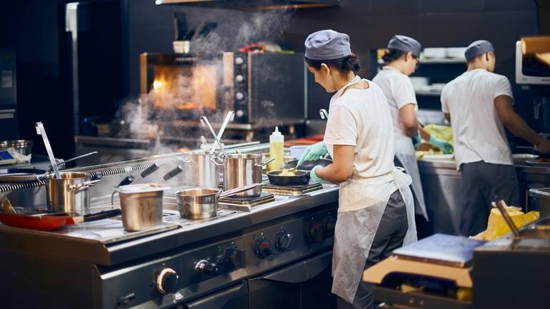 Line cook preparing a meal in a restaurant kitchen