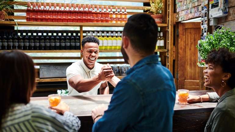 Server behind counter shaking hands with patron