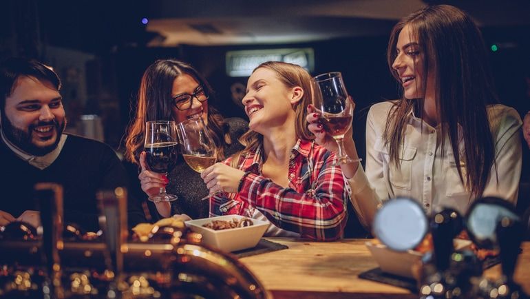 Friends laughing and raising their glasses