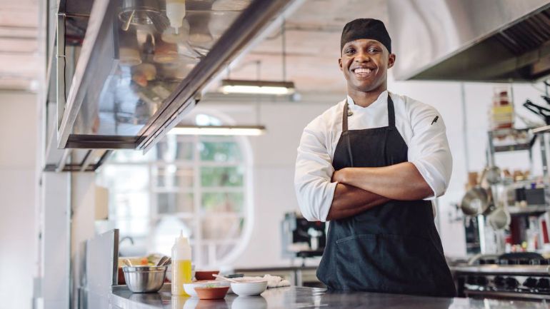 Line cook smiling in restaurant kitchen