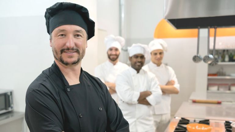 Four line cooks in a kitchen