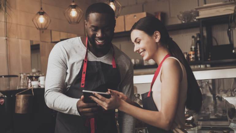 Employees looking at tablet together smiling