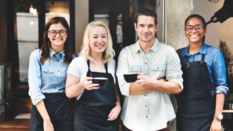 Employees standing outside of the restaurant they work at