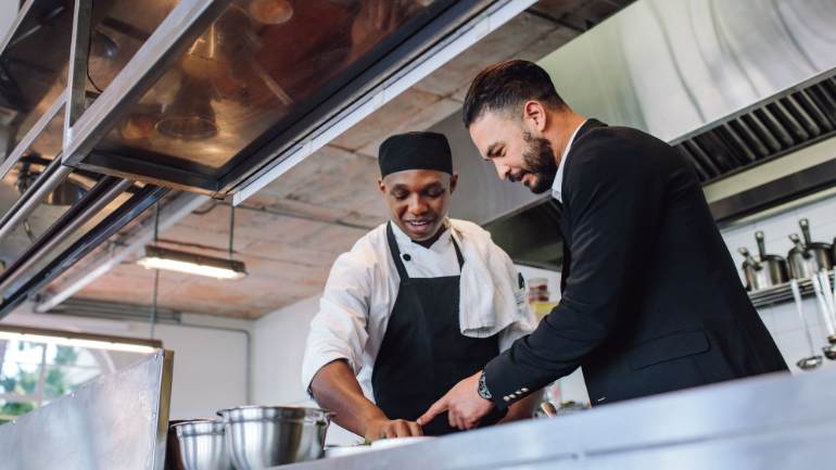 Chef and restaurant manager talking in kitchen