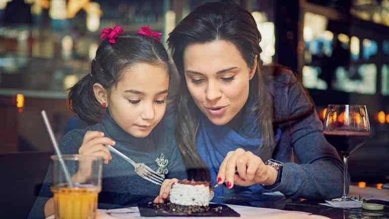 Mother and daughter share a restaurant dessert