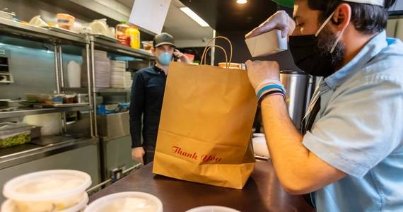 chef packing containers into a takeout bag