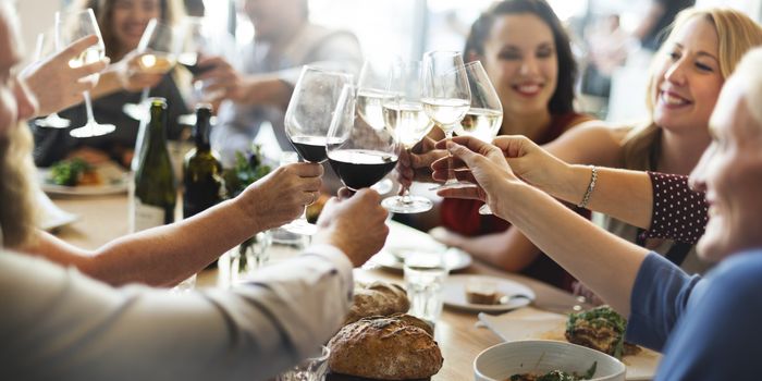 Family and friends around a table raising glasses