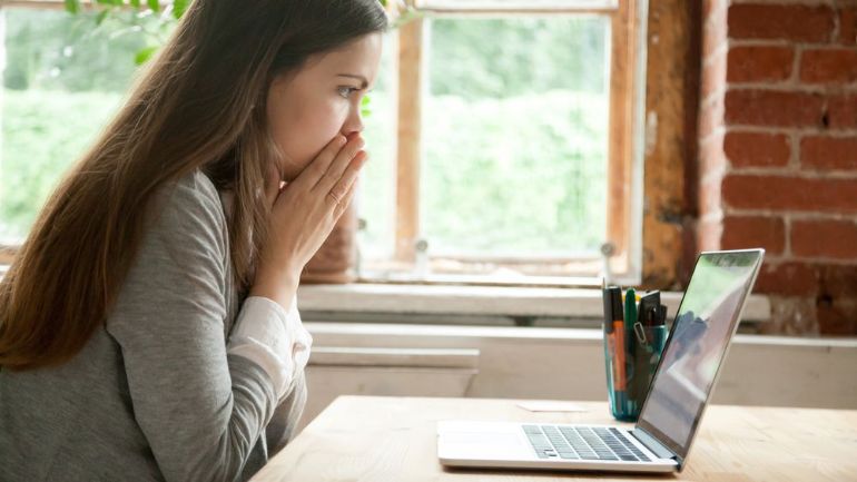 Restaurant manager thinking in front of laptop