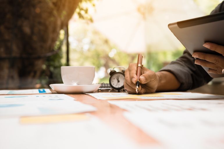 Person writing financial strategy with a fountain pen