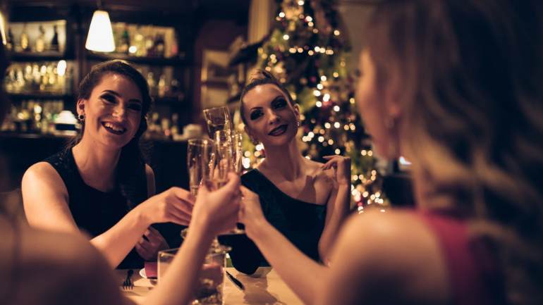 Friends around a table raising their glasses