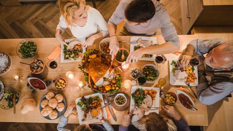 Family seated around a table laid with thanksgiving dishes