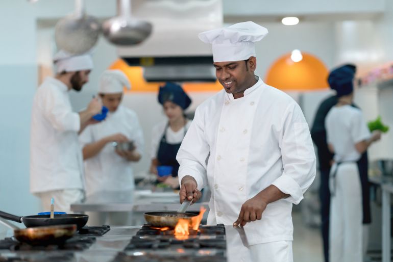 Chef sautéing over a commercial gas stove