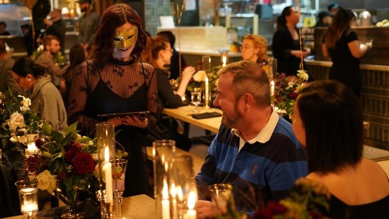 Waitress at reservation event taking orders from diners