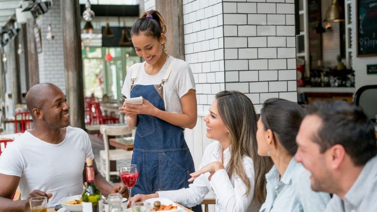 Server taking orders from a table of diners