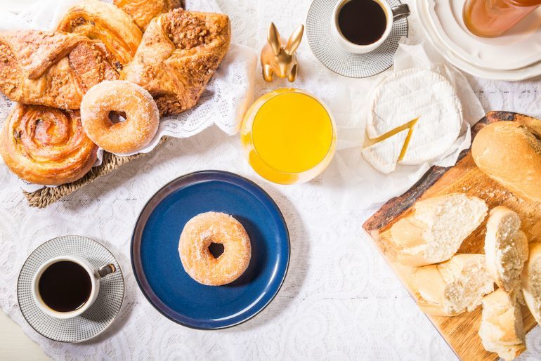 A table laid with cheese bread donuts pastries and coffee