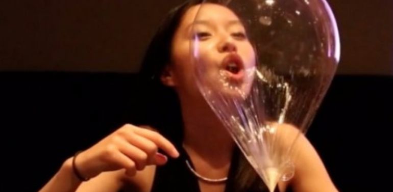 Woman blowing on a big bubble