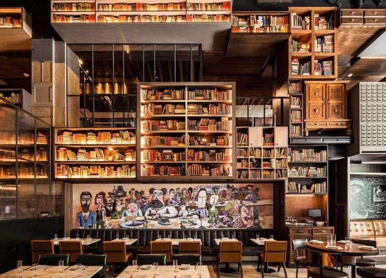 Shelves of books high above restaurant dining room