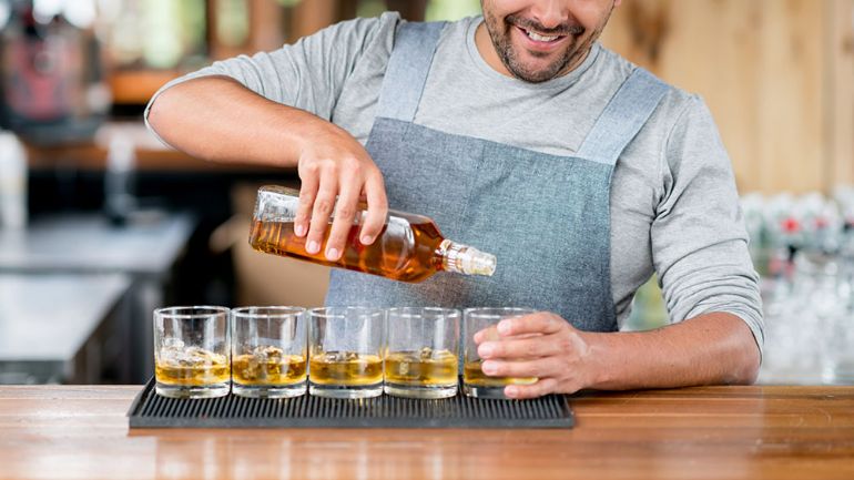 Bartender pouring into rocks glasses