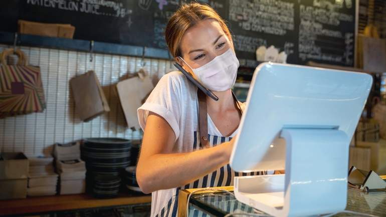 Cafe worker taking an order at counter POS