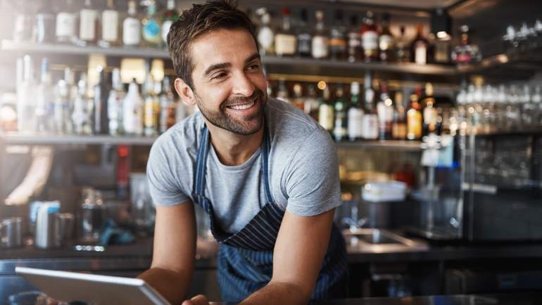 restaurant owner smiling with tablet POS