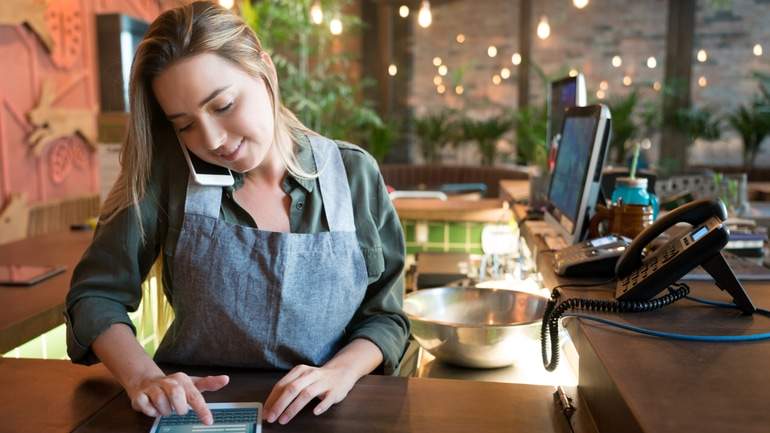restaurant worker inputting telephone order on tablet POS