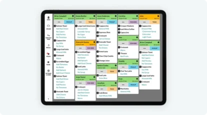 A kitchen display system tablet showing digital order tickets.