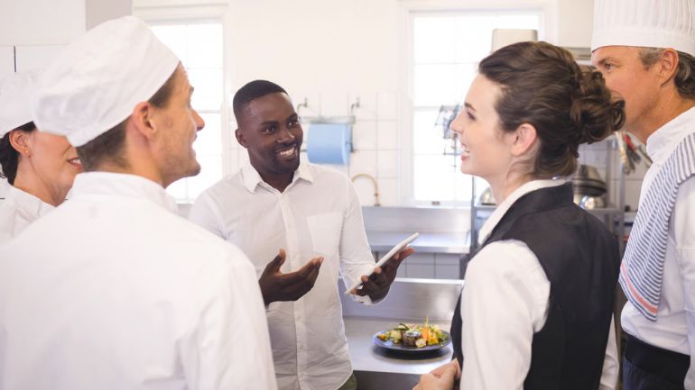 staff having informal meeting in restaurant kitchen