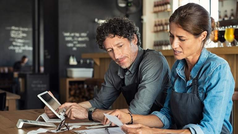 a manager going over new technology with a restaurant employee