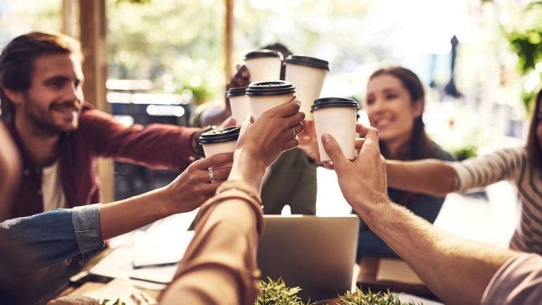 friends around a table raising their coffee cups