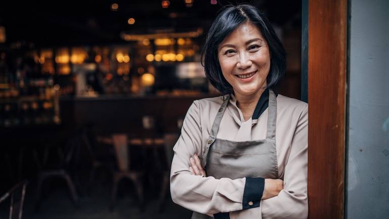 restaurant owner smiling with arms folded