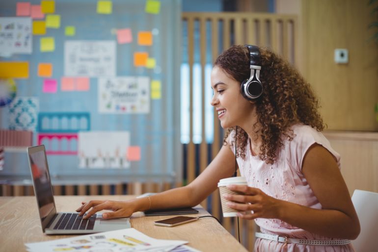 coffee shop customer listening to music on headphones